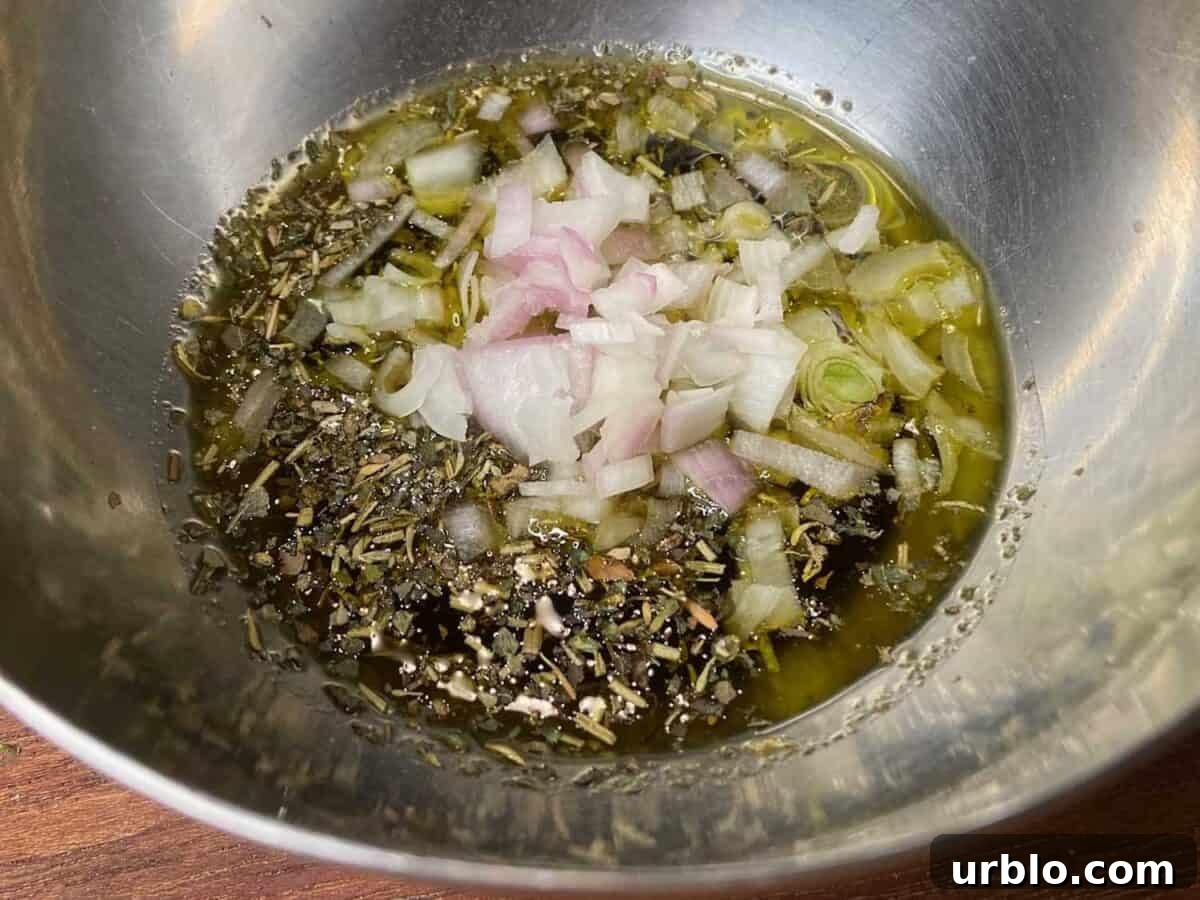 Oil, vinegar, and seasonings in a bowl.