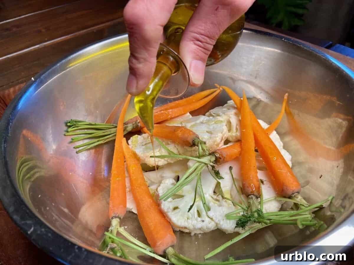 Sprinkling olive oil over vegetables in bowl.