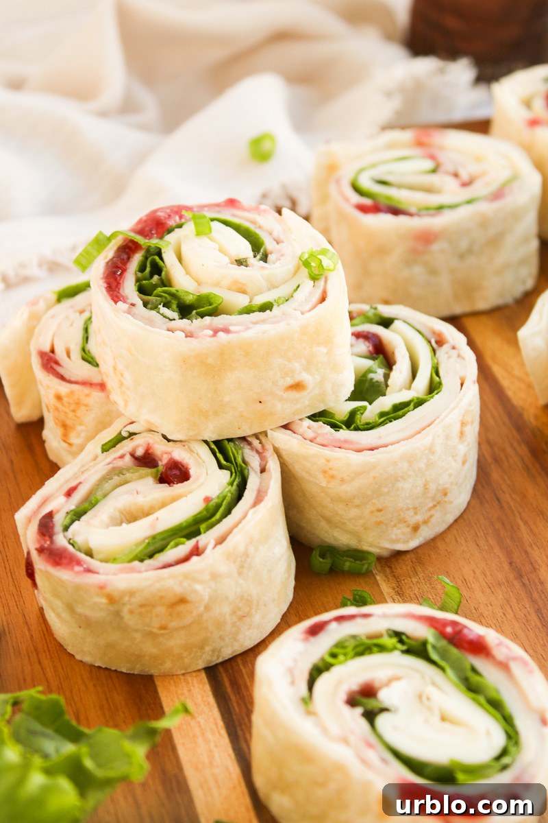 Cold Turkey and Cranberry Pinwheels for Leftovers 11 Sliced turkey pinwheels on a wooden board.