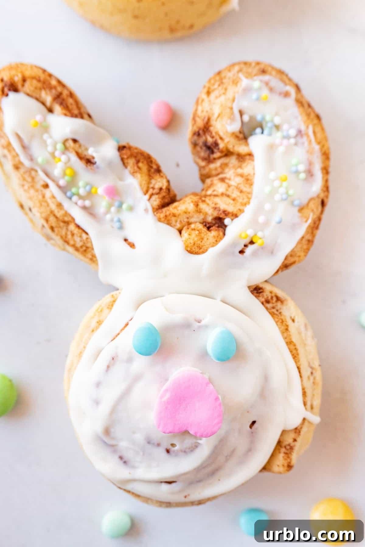 bunny cinnamon roll decorated with Easter candy on a white background.