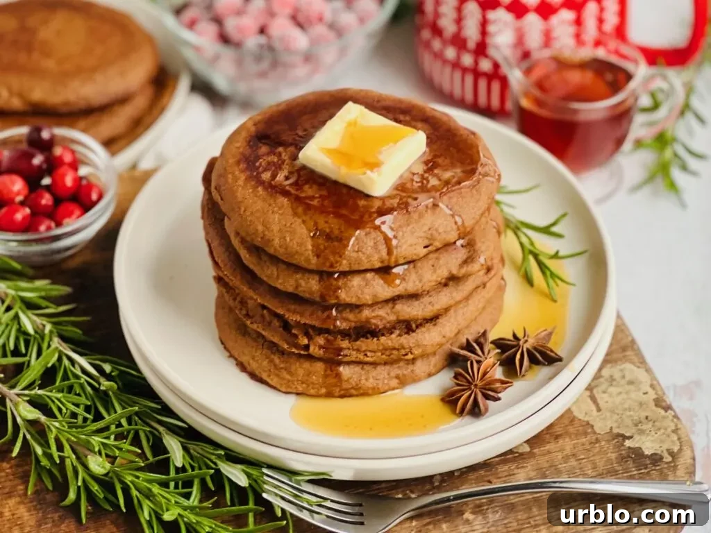 Pancakes on a plate with a small bowl of cranberries and syrup nearby.