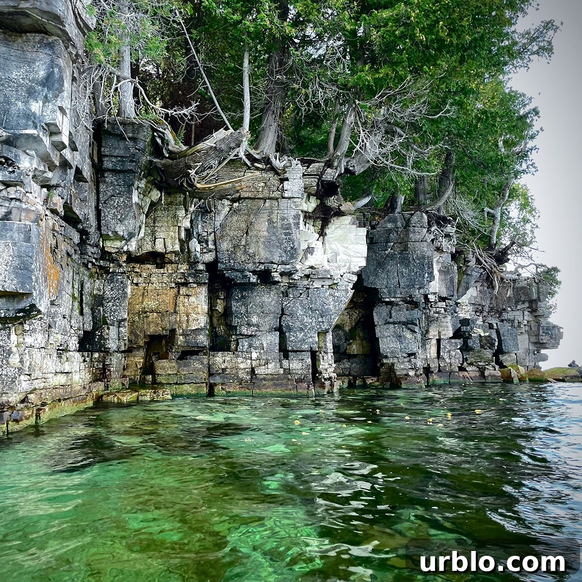 Kayaking past rocky cliffs along the Green Bay shore of Door County.