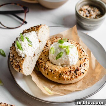 Two bialy bagels on a plate. Once is sliced down the center.