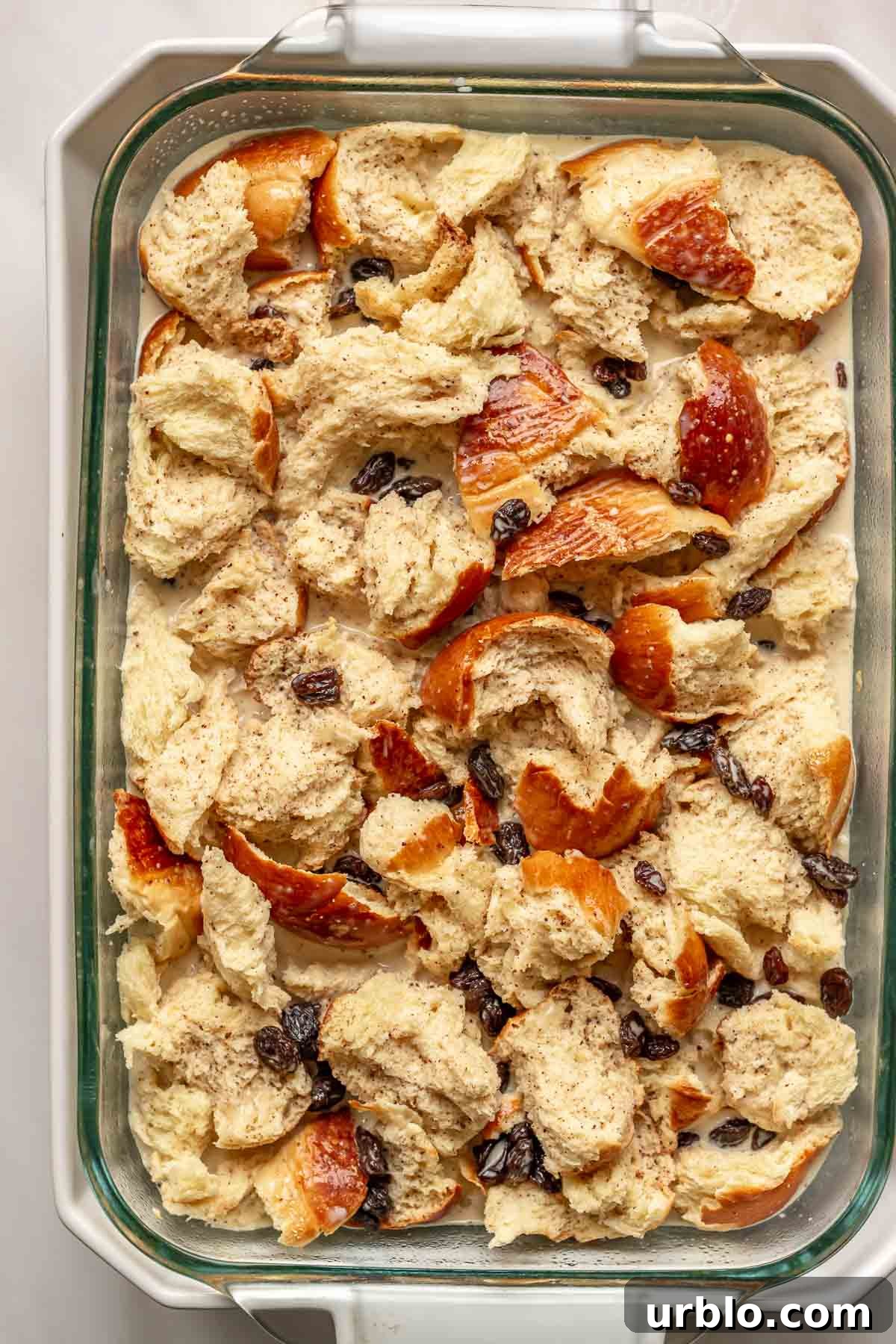 Soaked cinnamon bread pudding in a pan before baking.