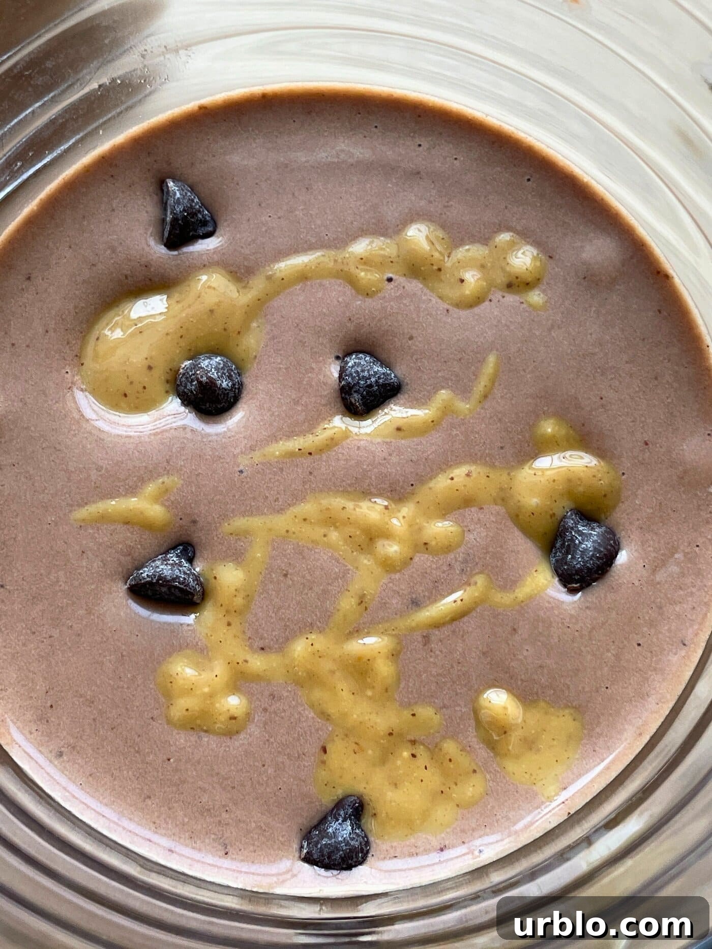 A banana chocolate peanut butter smoothie with peanut butter drizzled over the top.
