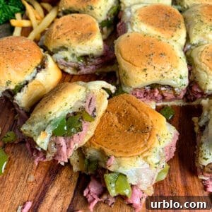 Philly cheesesteak sliders on sweet Hawaiian rolls covered in garlic butter sauce.