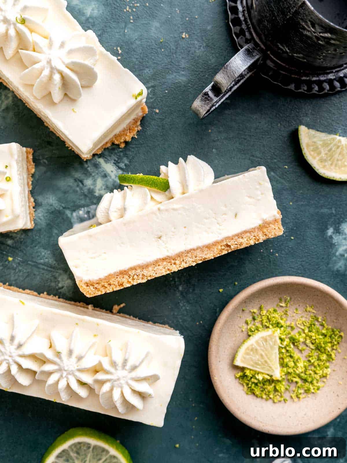 Close up of a no bake key lime cheesecake bar with graham cracker crust and whipped cream on top.