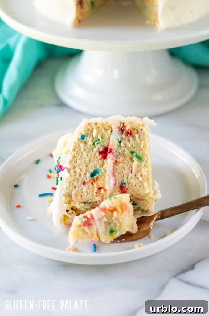Moist Gluten-Free Birthday Cake Recipe 3 a slice of gluten free funfetti cake on a white plate with a gold fork