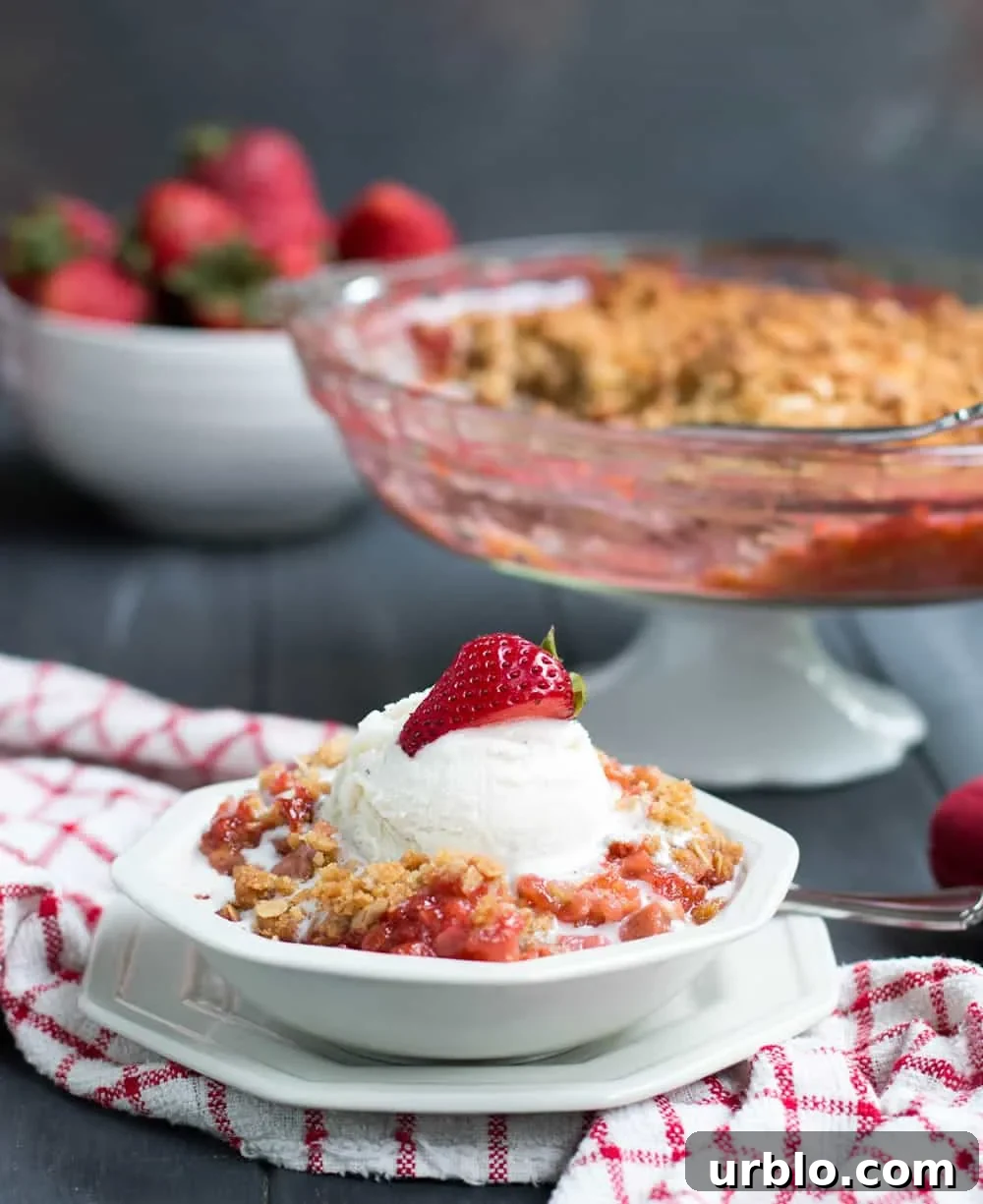 Bowl of Strawberry Rhubarb Crisp topped with vanilla ice cream
