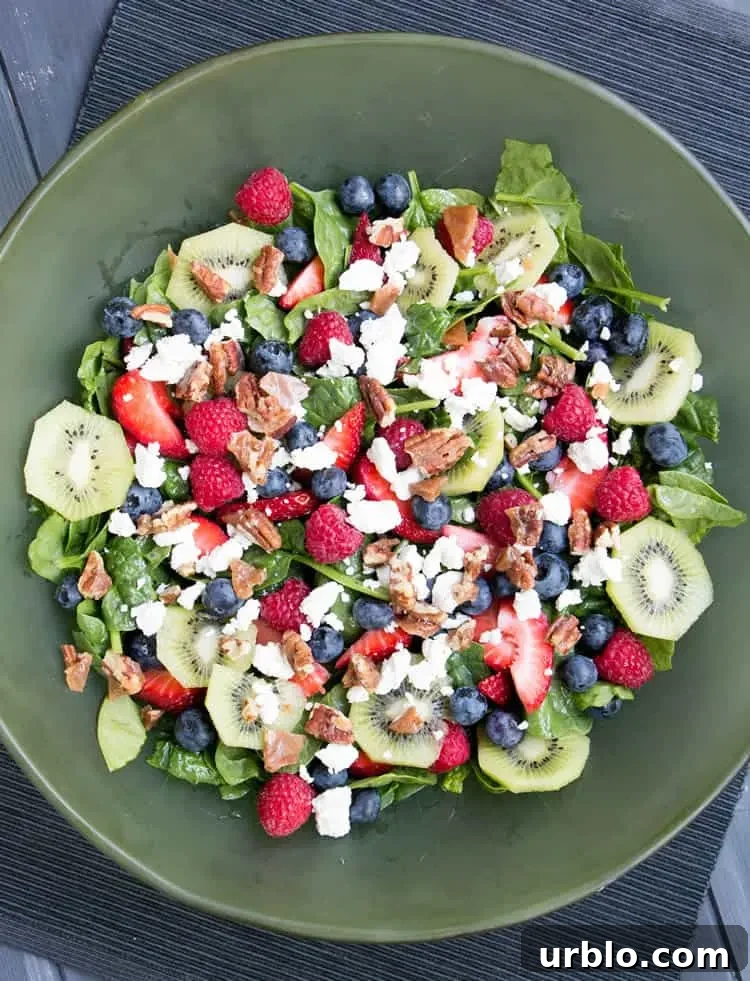 Kiwi Berry Spinach Salad with Honey Poppy Seed Dressing. Creamy goat cheese and candied pecans top this colorful salad with a dressing that's not too sweet!