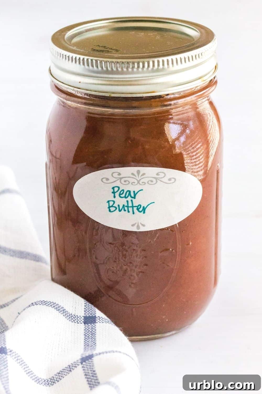 a jar of pear butter with a dissolveable label on it that reads "pear butter"