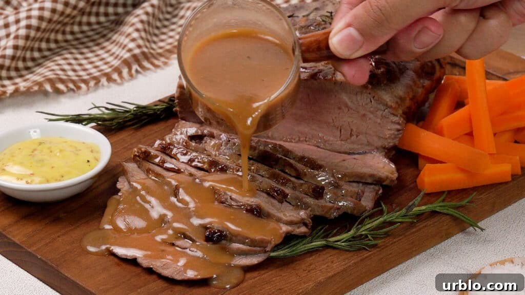 Air Fryer Roast Beef: Complete Guide to Tender, Juicy Results 9 Air Fryer Roast Beef on a wooden coaster poured with gravy