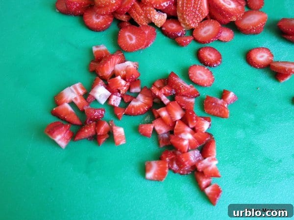 Low-Sugar Apple-Berry Salsa with Cinnamon Chips 4 Diced strawberries on a cutting board