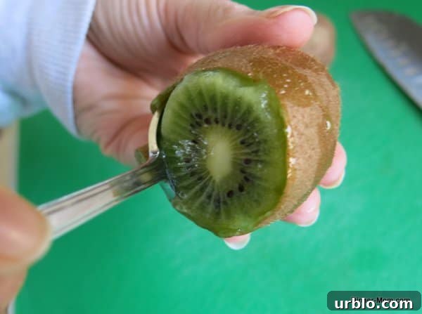 Low-Sugar Apple-Berry Salsa with Cinnamon Chips 5 spoon inside skin of kiwi demonstrating trick for taking skin off