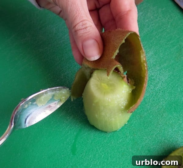 Low-Sugar Apple-Berry Salsa with Cinnamon Chips 6 Kiwi fruit being peels on a cutting board