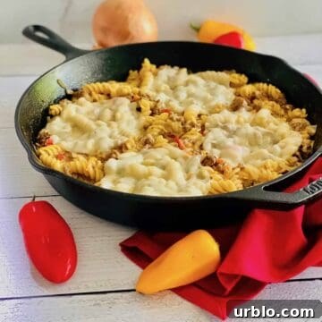 A skillet with pasta and melted cheese.