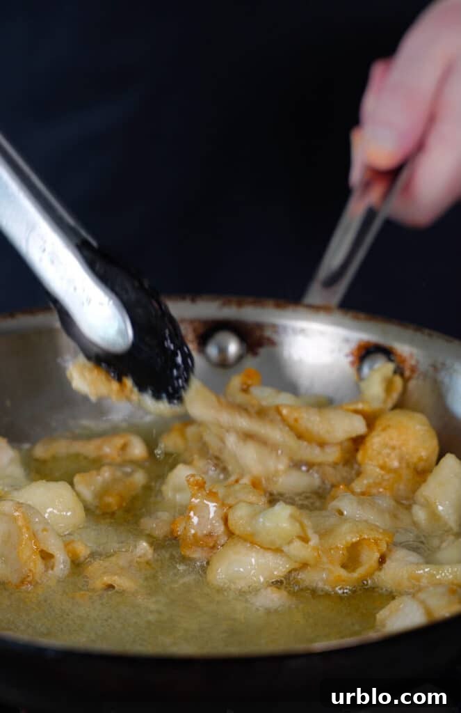 chicken skin being rendered down in a frying pan