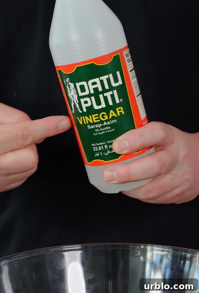 bottle of cane vinegar being held in a hand