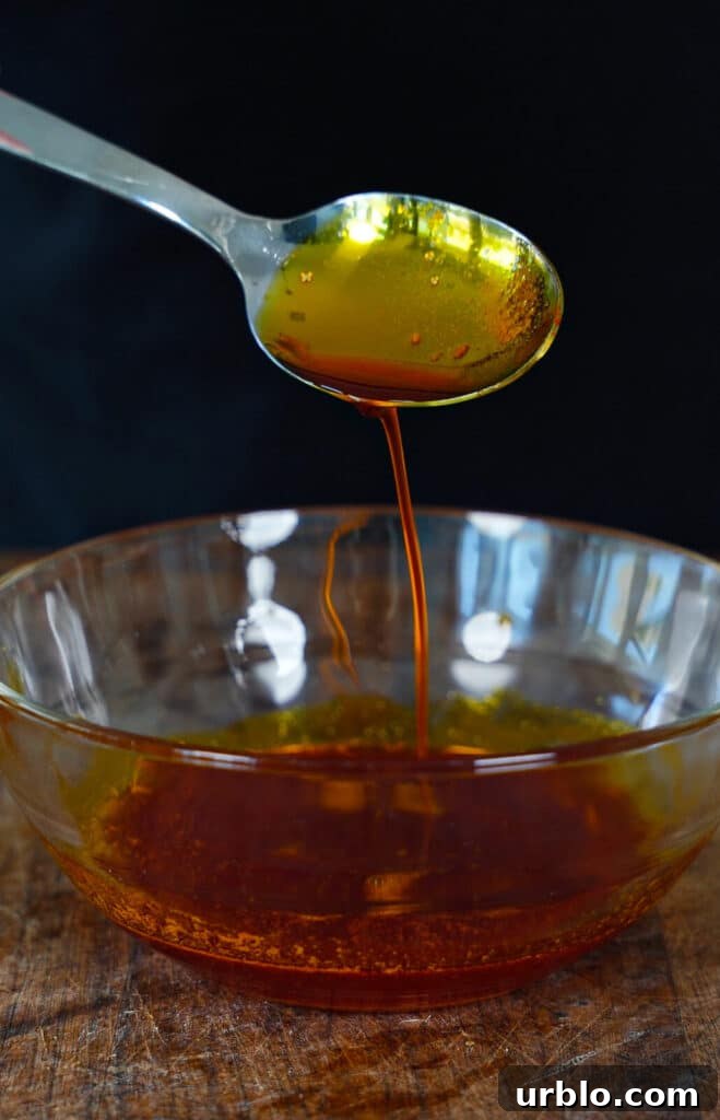 chicken oil being drizzled from a spoon