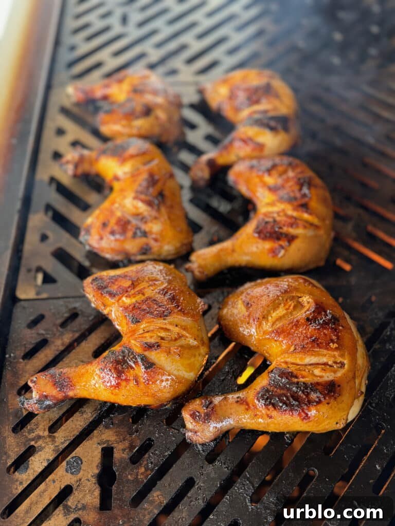 chicken inasal being grilled over fire on a grill grate