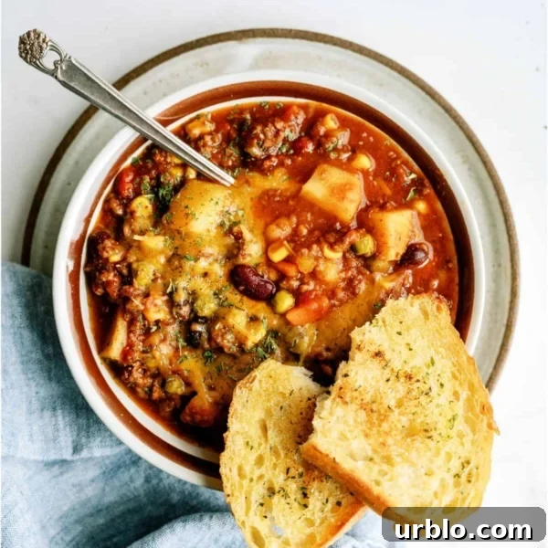 10 Make-Ahead Slow Cooker Freezer Meals Ready in 90 Minutes 7 A bowl of shepherd's pie chili topped with herbs, served with a spoon and two slices of toasted bread on the side.