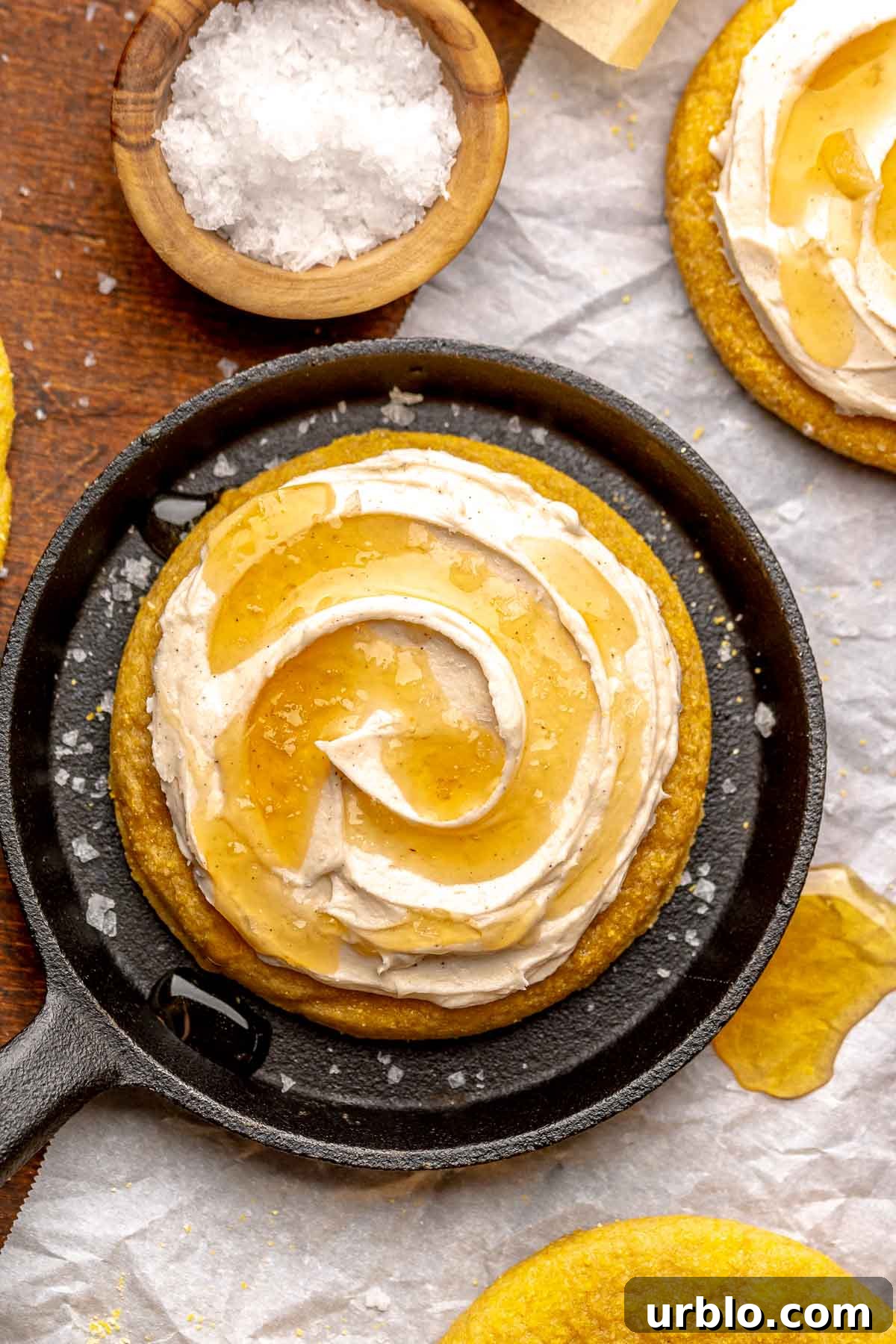 A frosted cornbread cookie in a mini cast iron skillet.