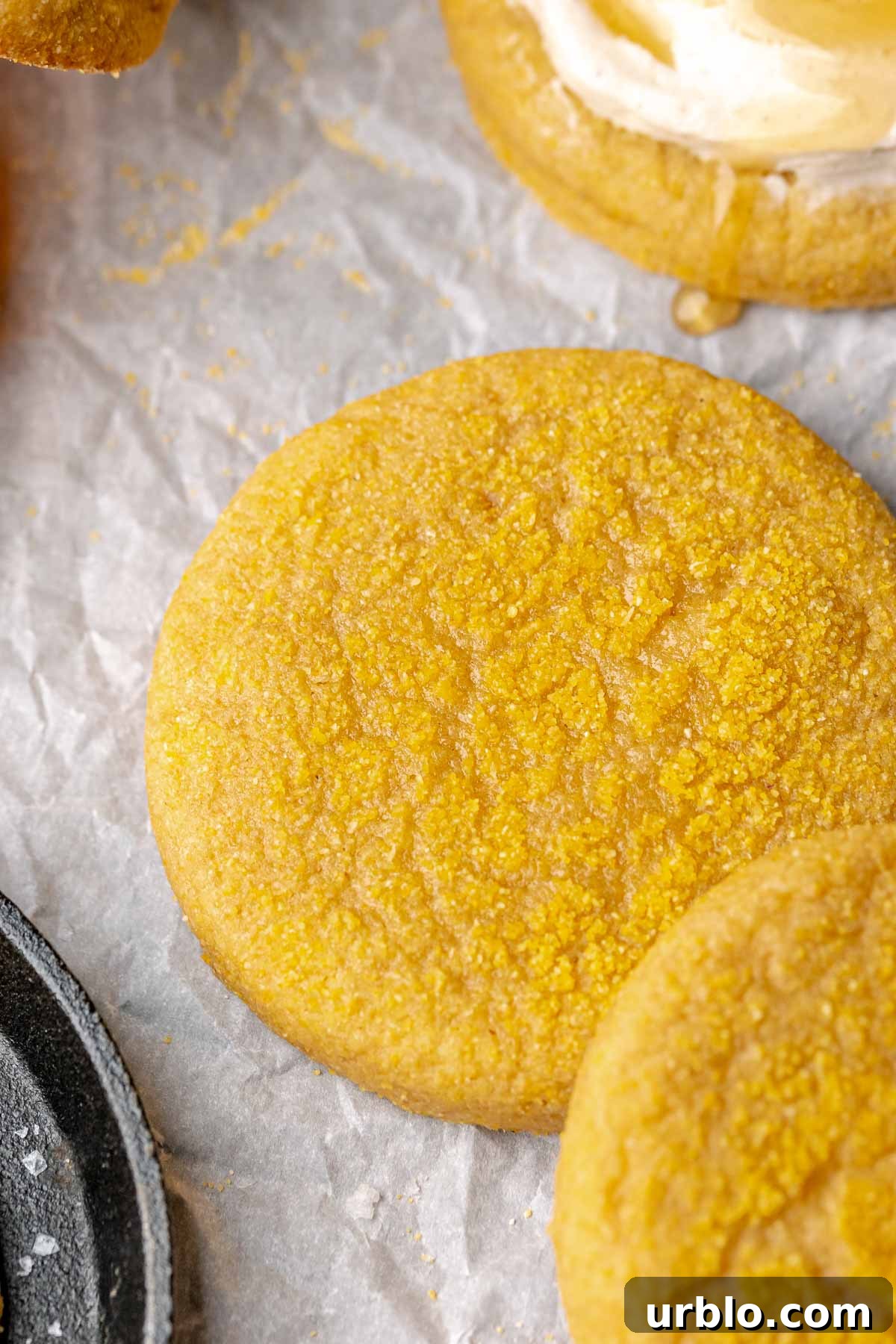 Unfrosted cornbread cookie on parchment paper.