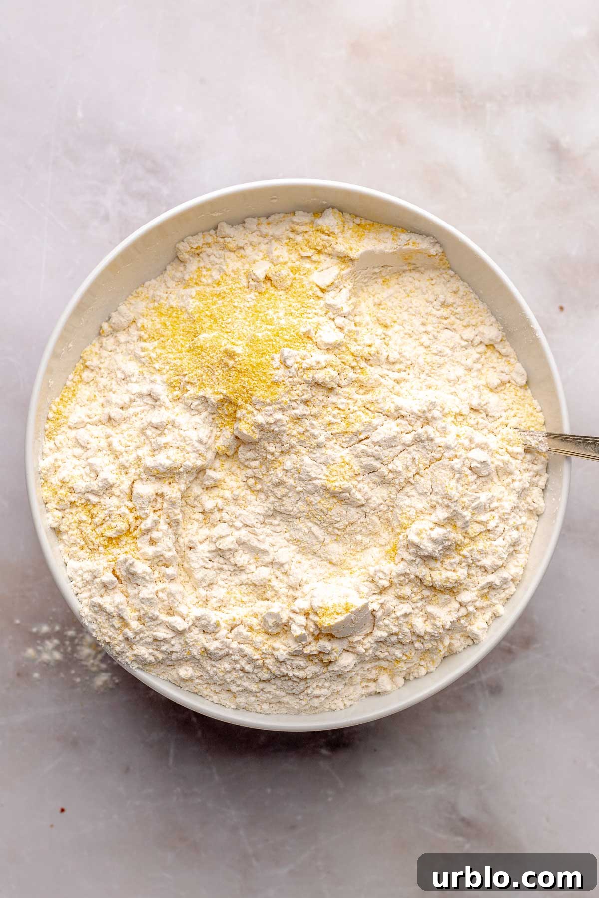 Cornmeal and flour mixed together in a bowl.