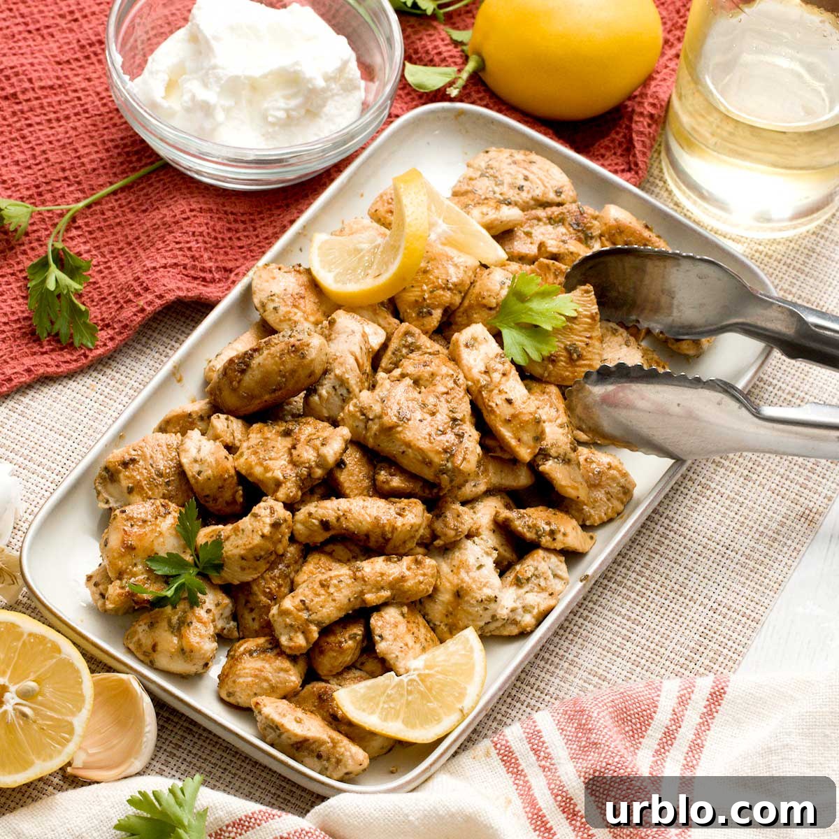 A dish with greek yogurt marinated chicken breast diced in bite-sized pieces.