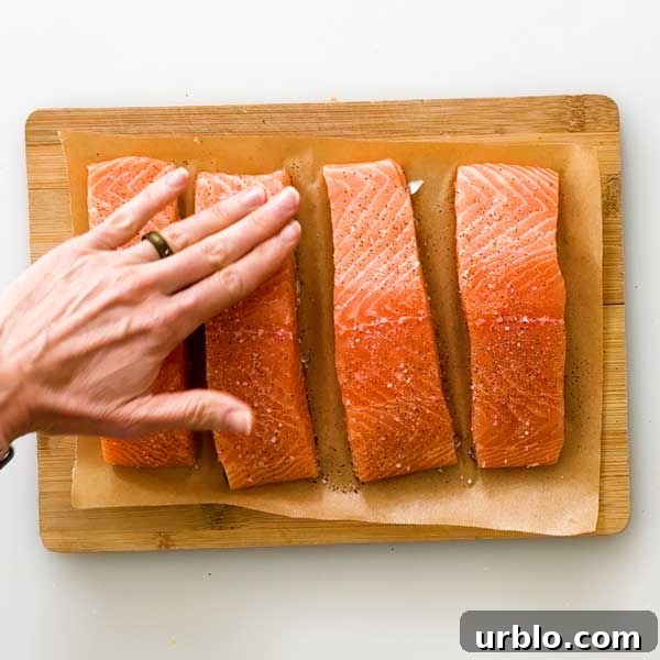 Seasoning salmon with salt and pepper.