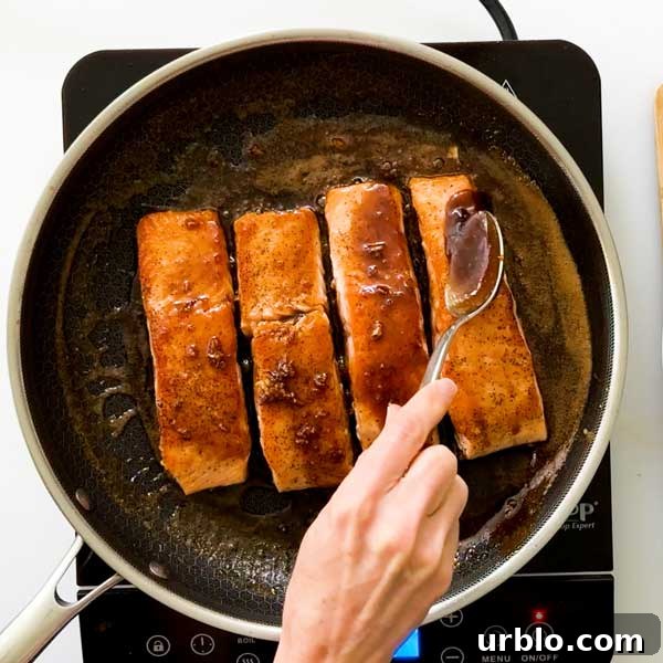 Basting salmon with the honey garlic butter sauce.
