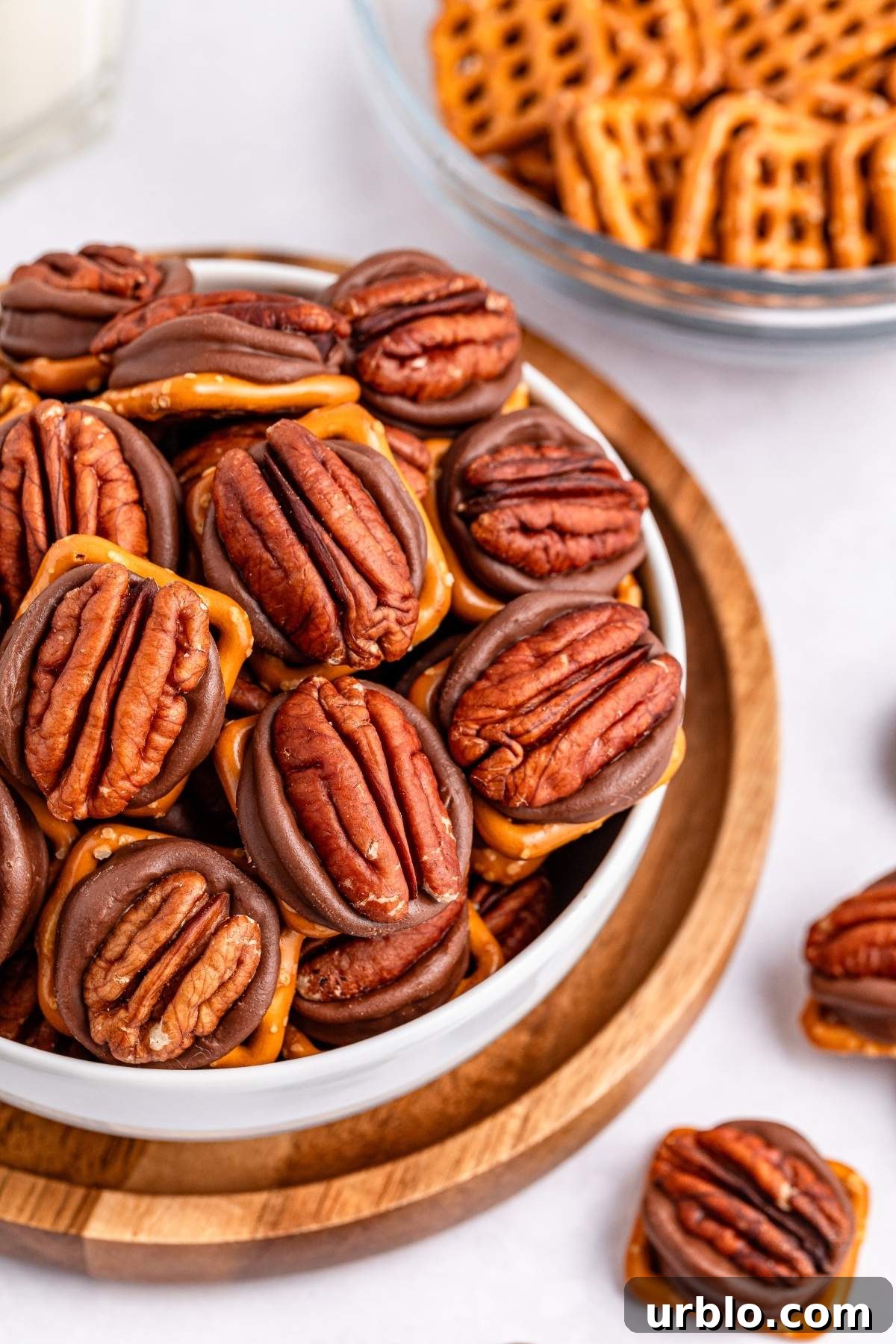 A bowl of 3-ingredient pretzel turtle bites tempts the taste buds, while in the background, more pretzels beckon from a separate bowl.