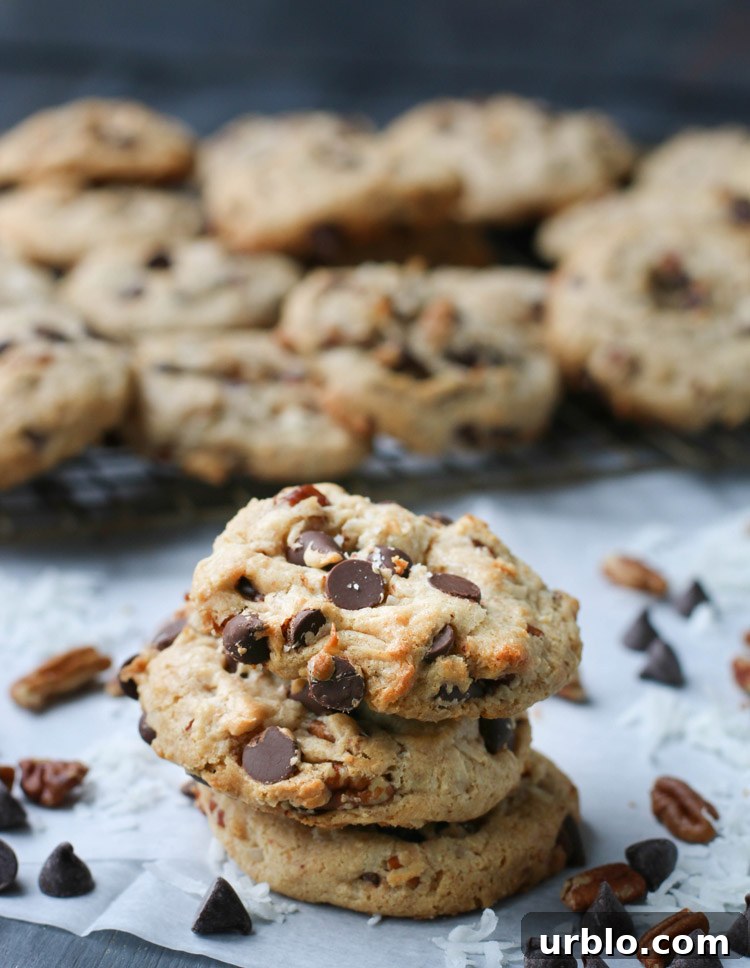 Three treasure cookies stacked on top of each other in front of a cooling rack full of baked cookies