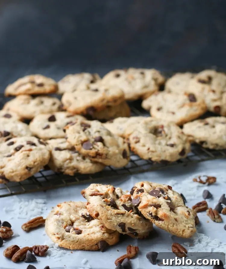 Three treasure cookies resting on each other in front of a cooling rack full of baked cookies