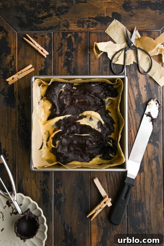 Fudgy Swirled Brownie-Blondie Bars: Chocolate-Vanilla Marble Treats 9 Using spatula to swirl brownie batter into blondie batter.