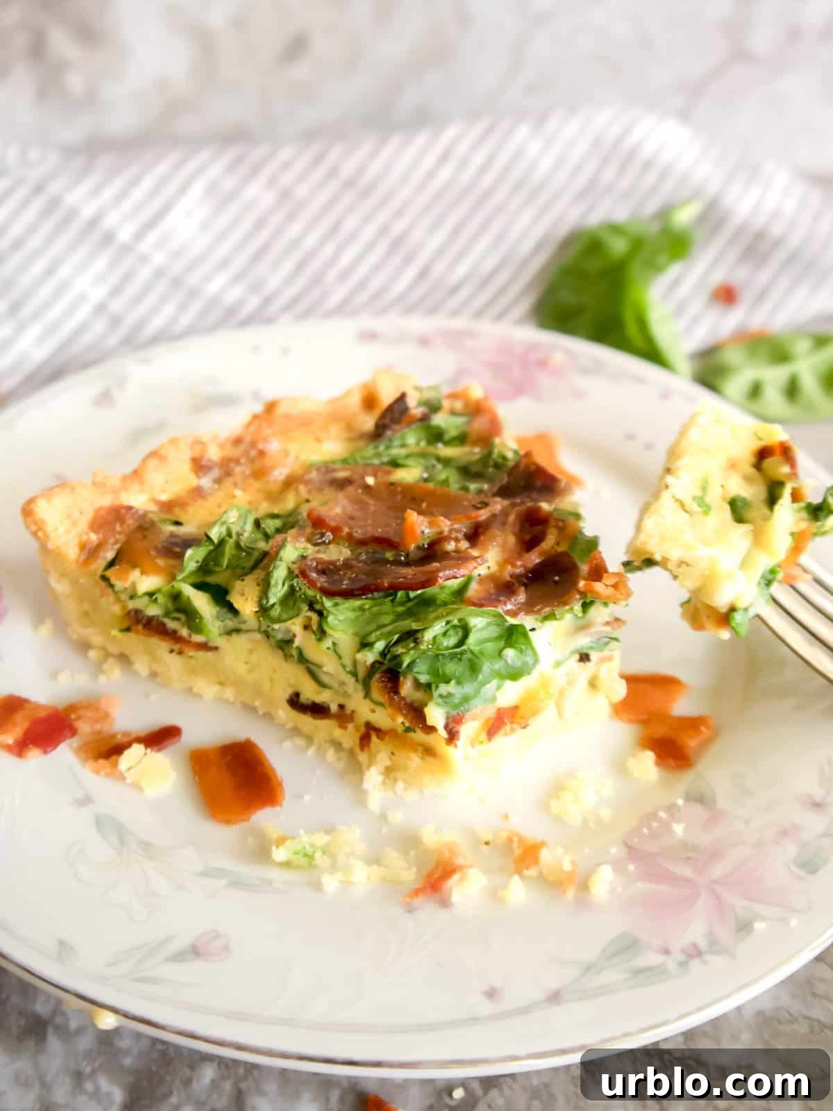 A slice of Paleo Gluten-free Spinach Bacon Quiche.