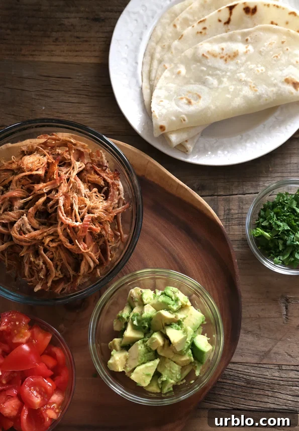 Overhead view of bowls of toppings and tortillas on wooden surface 