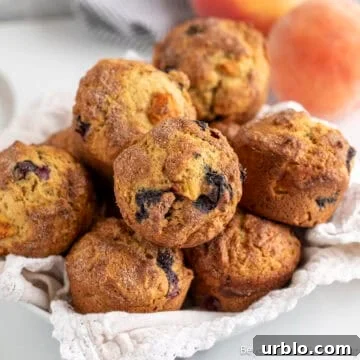 A basket filled with blueberry peach muffins.