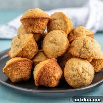 Mini Banana Muffins stacked on a black plate.
