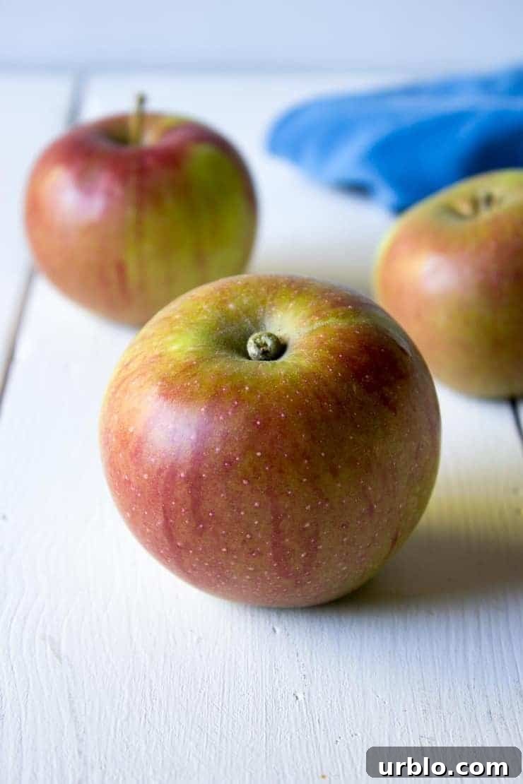 Fresh apples on a white board with a blue napkin in the background. 