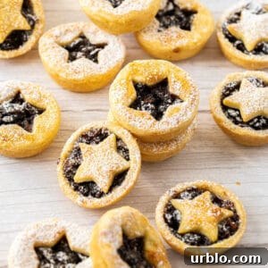 Mince pies dusted with icing sugar on a bench.