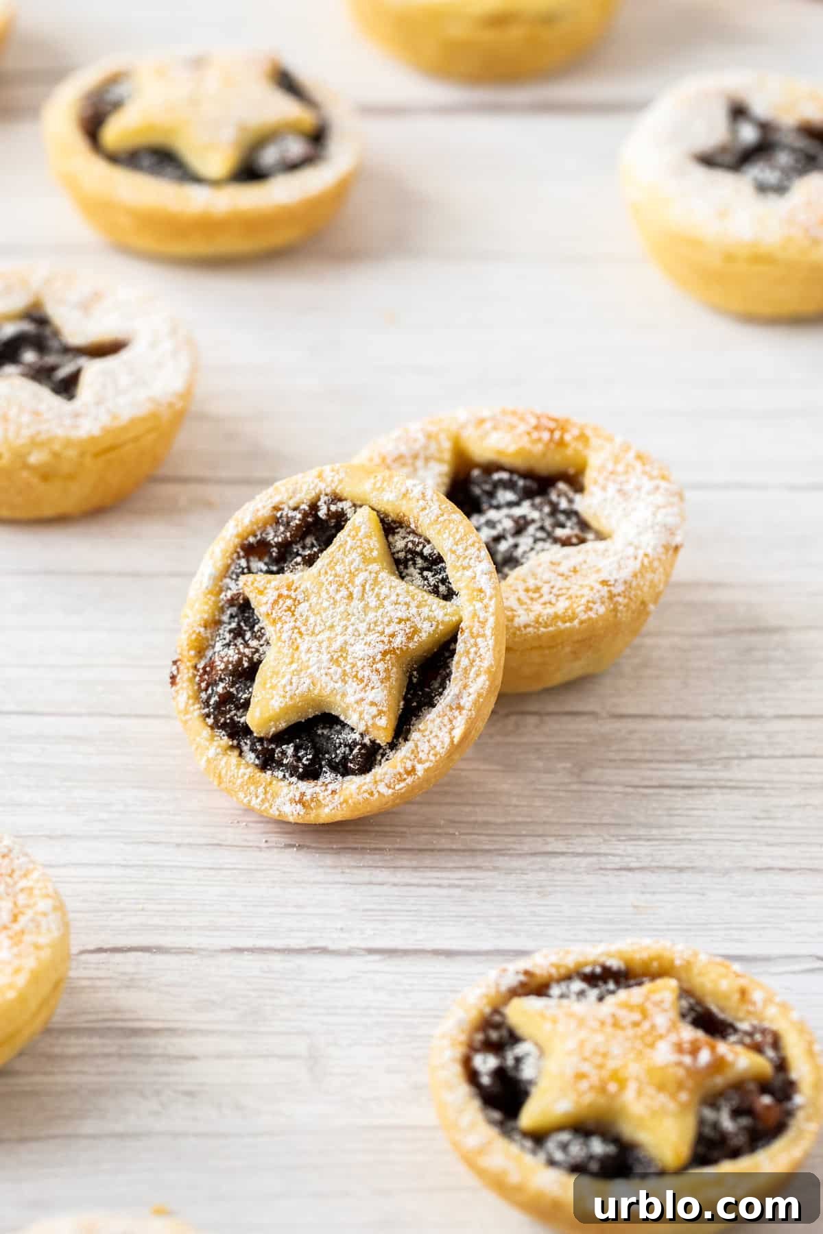 Up close shot of mince pies sitting on a bench.