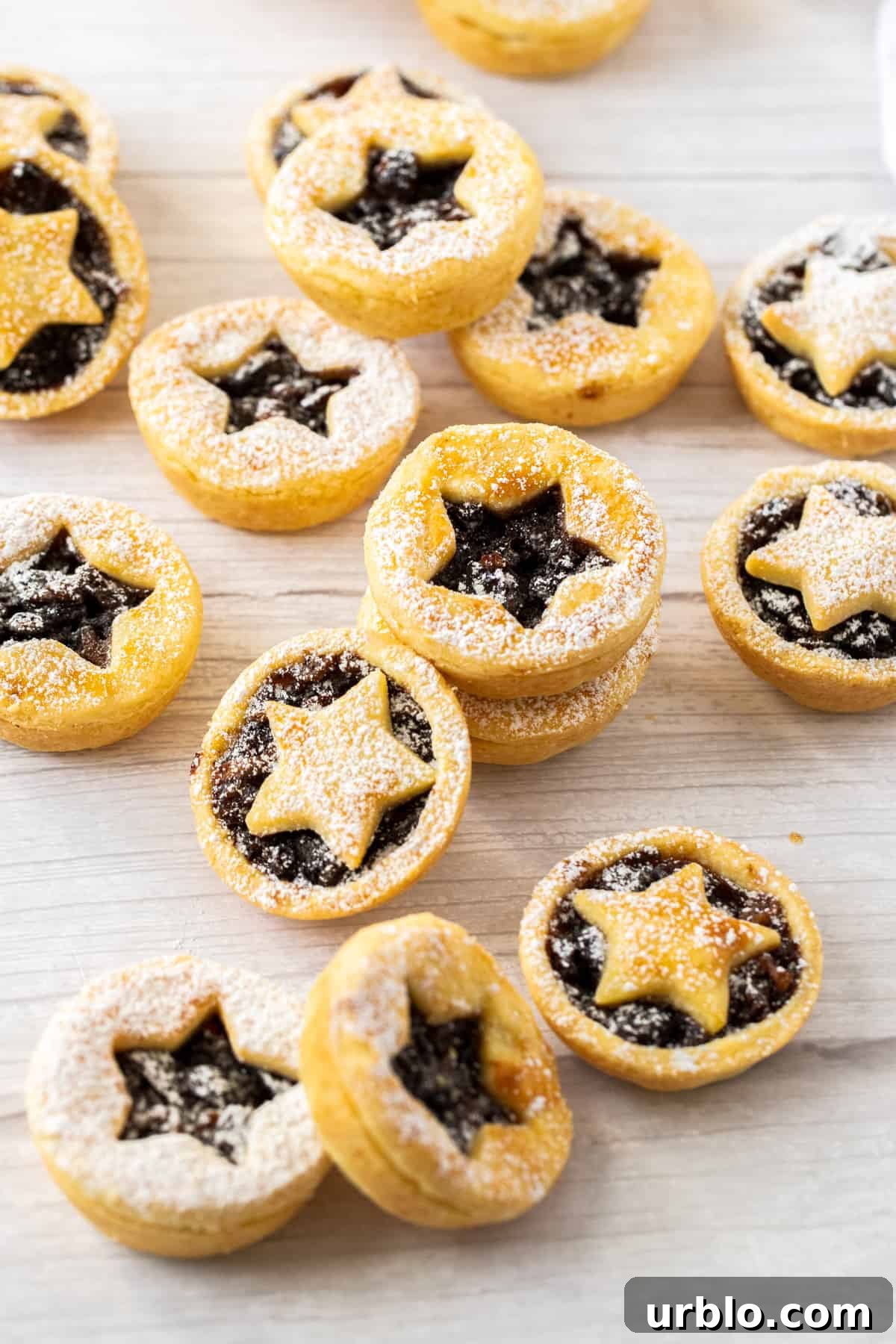 Overhead shot of mince pies sitting on a bench.