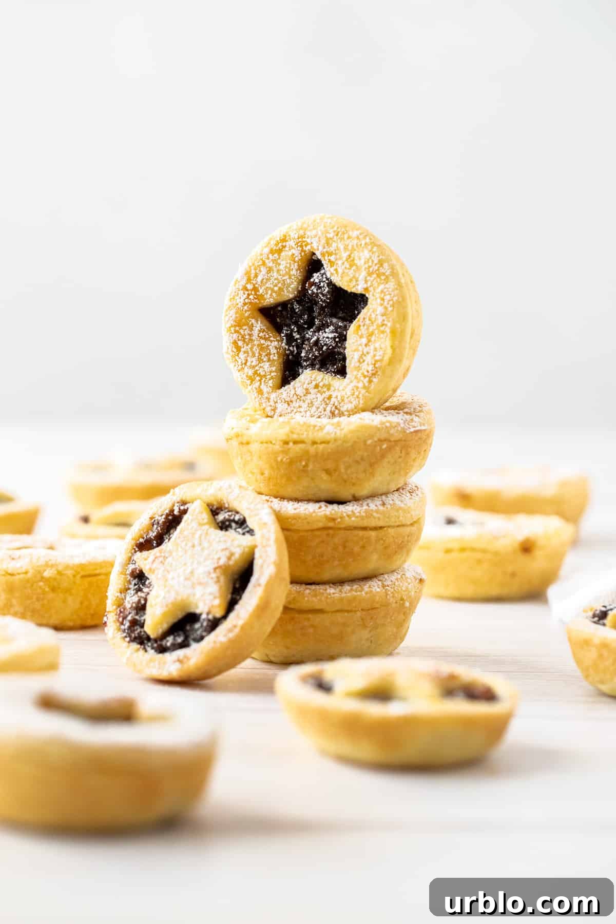 Stack of fruit mince pies, with some more pies around the edge.