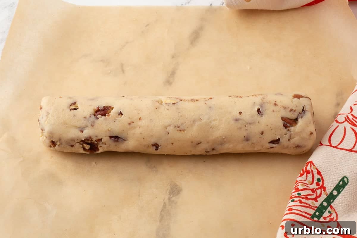 Chocolate-Dipped Pecan Sandies Cookies: Crunchy Butter Shortbread 8 Cookie dough log on piece of parchment paper.