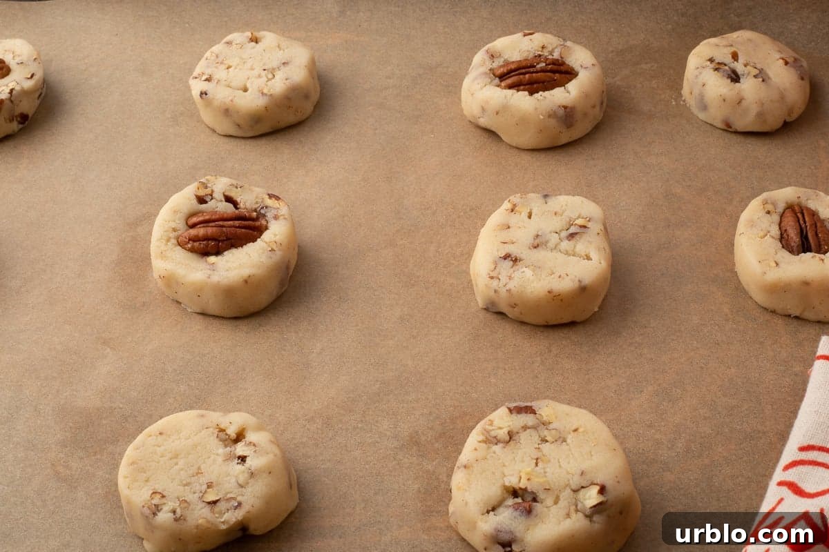 Chocolate-Dipped Pecan Sandies Cookies: Crunchy Butter Shortbread 9 Unbaked pecan sandies on parchment lined baking sheet, ready to go into the oven.
