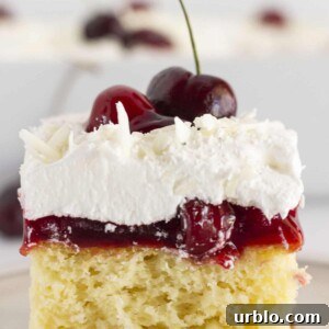 Serving a slice of white forest cake with a fresh cherry on top.