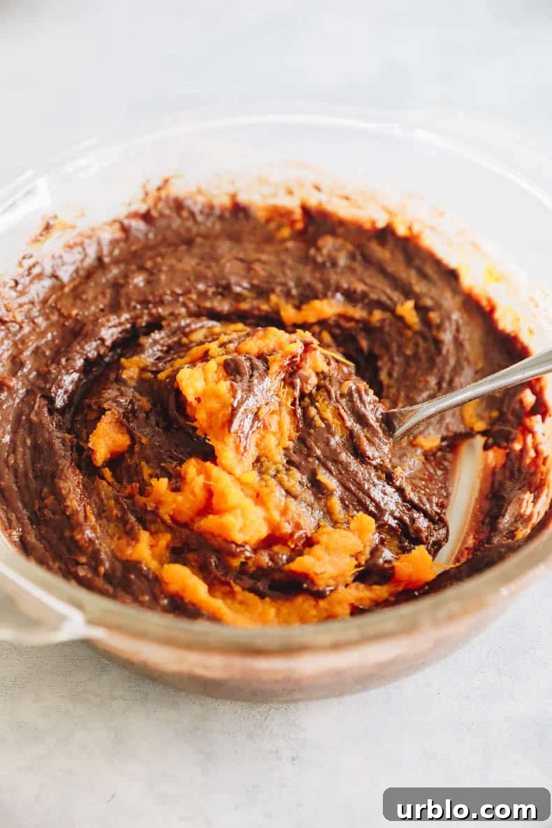 sweet potato brownie batter in a clear glass bowl.