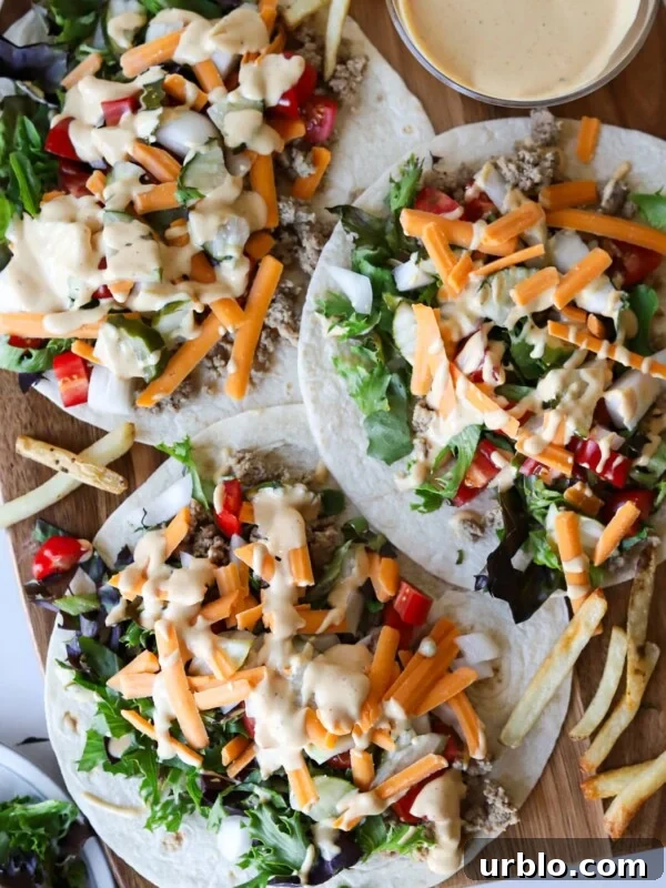 Big mac wraps on a wooden board with sauce.