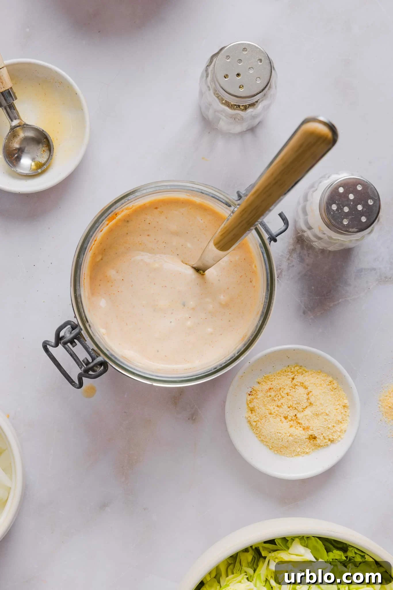 Mixed big mac sauce in a large jar with a spoon.